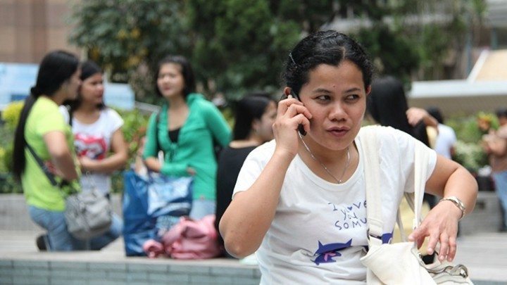 A domestic worker in Hong Kong on her phone. Image by KC Wong.